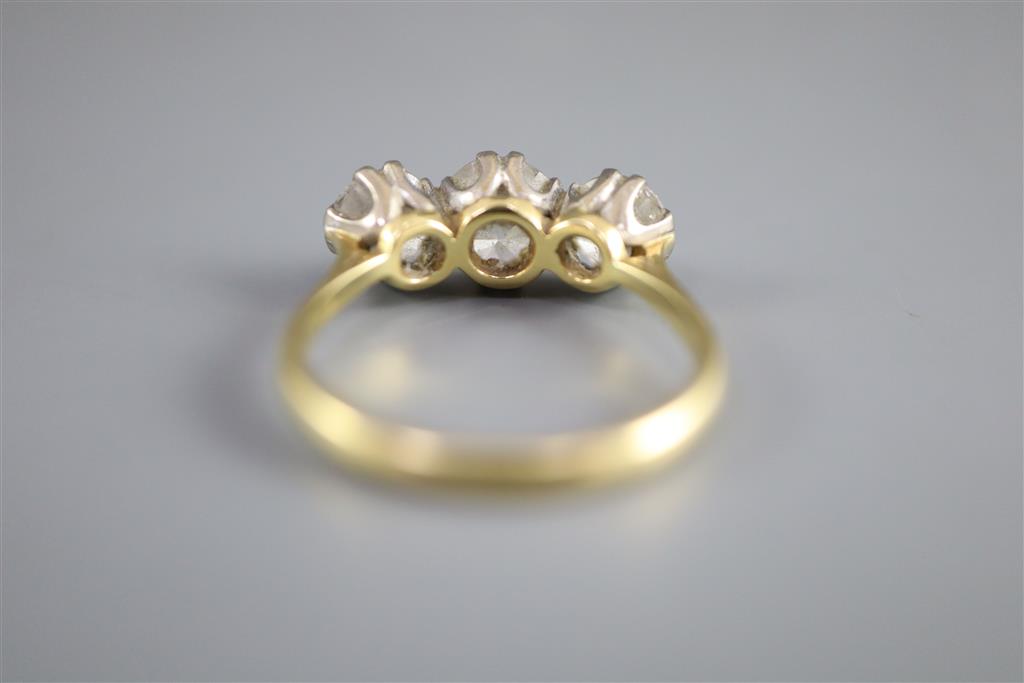 A modern 18ct gold and three stone brilliant cut diamond ring,